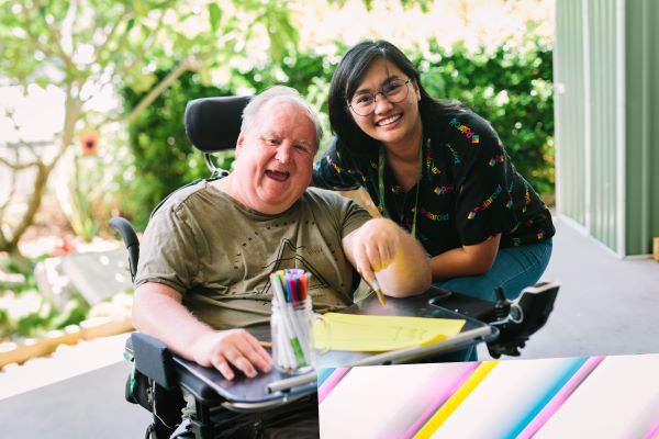 Happy man on a wheelchair and disability worker in one of our specialist disability apartments in Brisbane