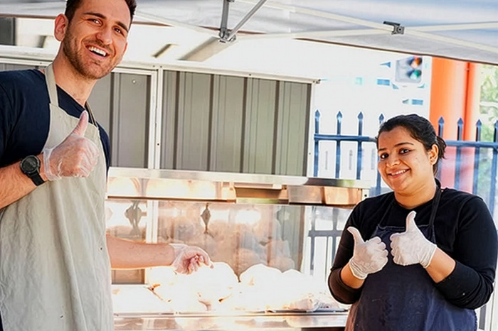 Corporate team volunteering at BBQ community lunch in Brisbane