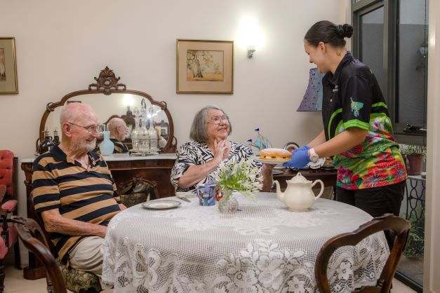 Couple enjoying morning tea served by WMQ staff member Residents being served a high tea