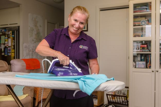 NDIS in home support worker ironing clothes in a home in Brisbane