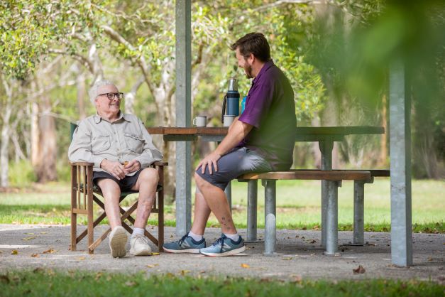 A home care resident and staff member share tea in the park