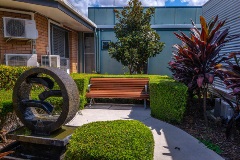 Emmaus sculpture and green outdoor area