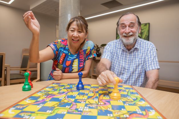 Lady and man playing a game of snakes and ladders