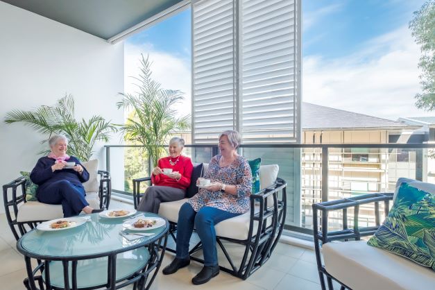 Residents enjoying a coffee on their balcony with friends at Rosemount