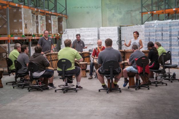 Wesley Arts African drumming workshop with a group in a warehouse
