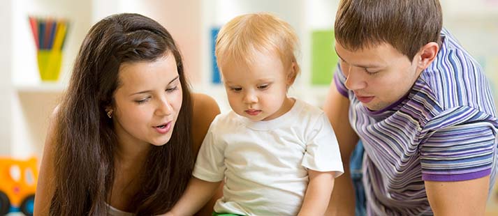 Young parents reading to a toddler