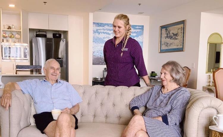 Young lady in uniform in home of two older people